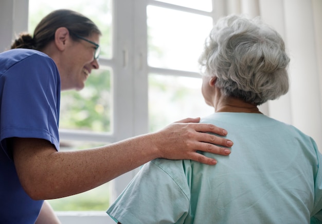 Krankenschwester, die um einer alten frau sich kümmert Kostenlose Fotos