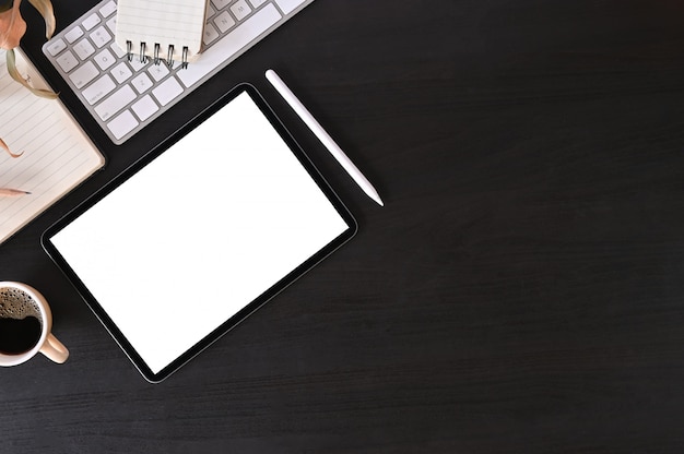 Kreativer schreibtischarbeitsplatz mit modelltablet-computer und büroausstattung auf schwarzer tabelle, draufsicht. Premium Fotos