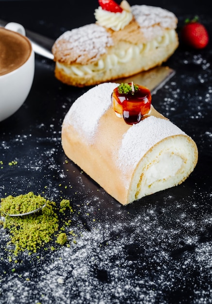 Kuchen mit puderzucker und tasse cappuccino auf dem tisch | Kostenlose Foto