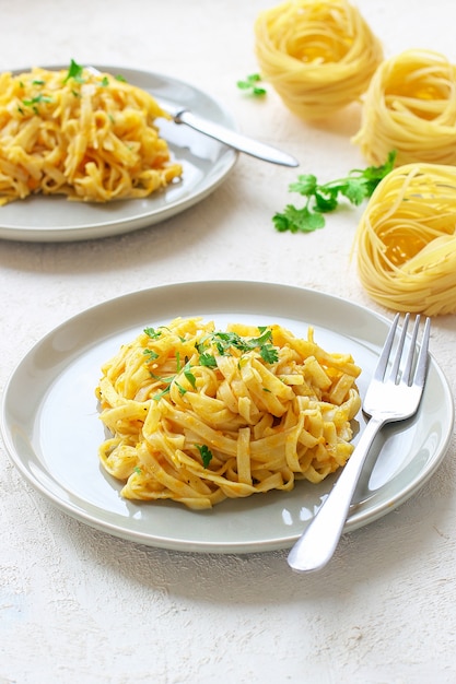 Kürbis alfredo fettucine pasta in einer keramikplatte mit frischen ...