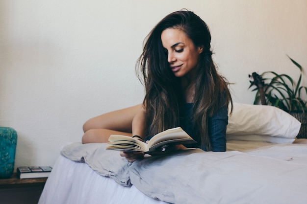 Lchelnde Frau Die Im Bett Liest Kostenlose Foto