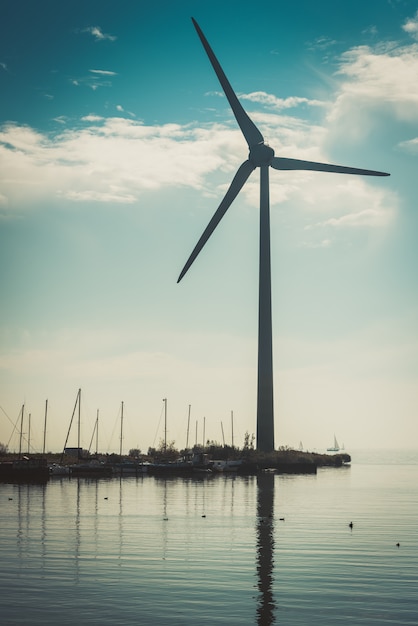 Ländliche wasserlandschaft mit arbeitswindkraftanlage Premium Fotos