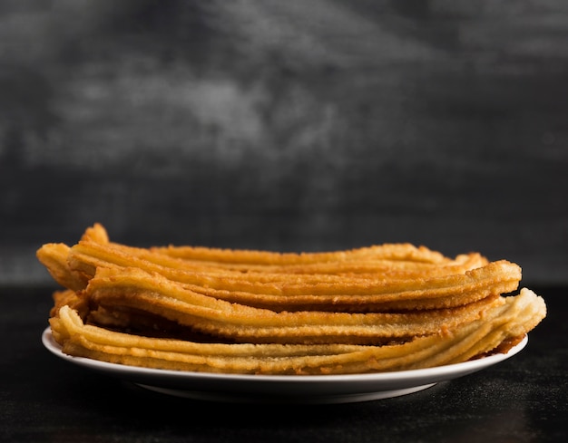 Lange sicht der weißen platte mit churros gefüllt Kostenlose Fotos