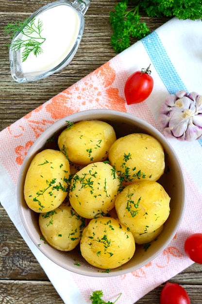 Leckere gekochte junge kartoffeln mit butter und dill in einer schüssel ...