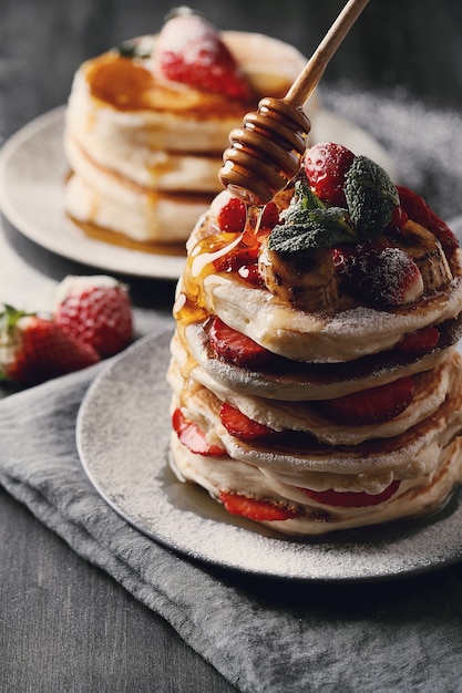 Leckere pfannkuchen mit erdbeeren und honig | Kostenlose Foto