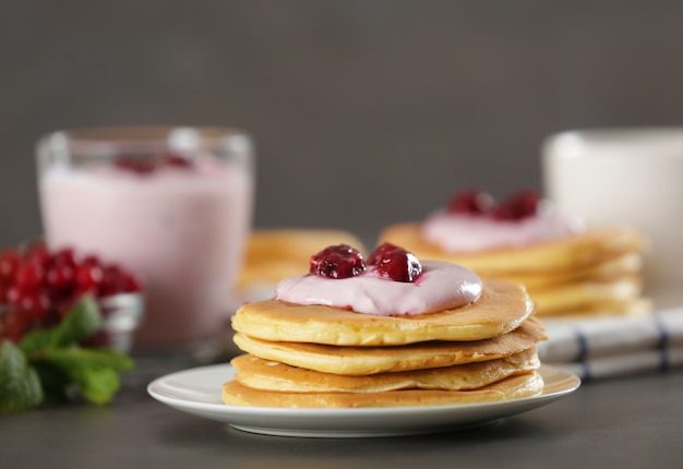 Leckere pfannkuchen mit joghurt und beeren auf dem tisch | Premium-Foto