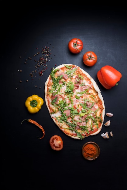 Leckere pizza mit zutaten und gewürzen auf tapete Kostenlose Fotos