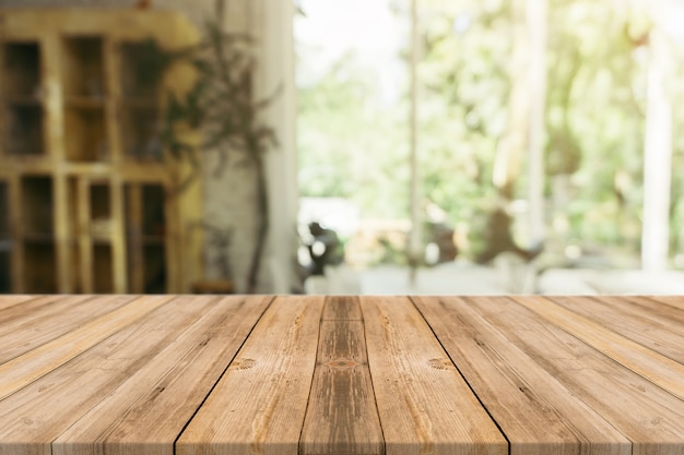 Leere tabelle des hölzernen brettes vor unscharfem hintergrund. braunes holz der perspektive über unschärfe in der kaffeestube - kann für anzeige verwendet werden oder ihre produkte zusammenbauen. spannen sie oben für anzeige des produktes an. Kostenlose Fotos