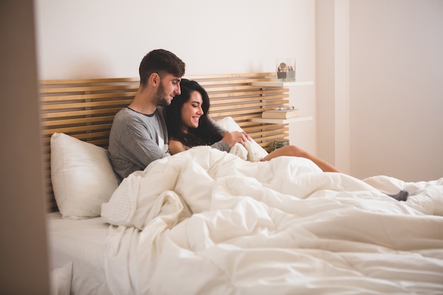 Liebespaar auf dem bett liegend Kostenlose Foto