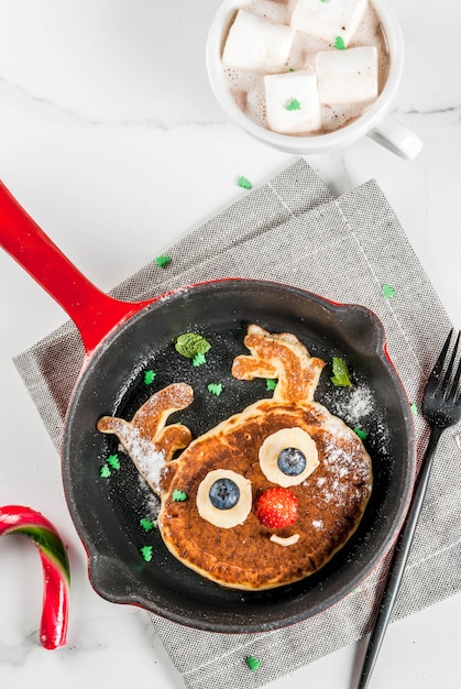 Lustiges Essen Zu Weihnachten Kinderfruhstuckspfannkuchen Verziert Wie Ren Mit Heisser Schokolade Mit Eibisch Weisse Tabelle Premium Foto