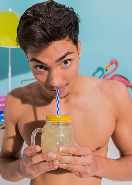 Lustiges trinkendes cocktail des jungen mannes im studio Kostenlose Fotos
