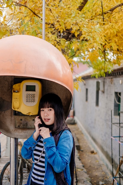 Mädchen am öffentlichen telefon sprechen | Kostenlose Foto