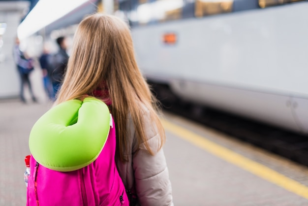 Mädchen Wartet Auf Den Zug Mädchen Mit Einem Rucksack Und Mit Grünem Nackenkissen Premium Foto 