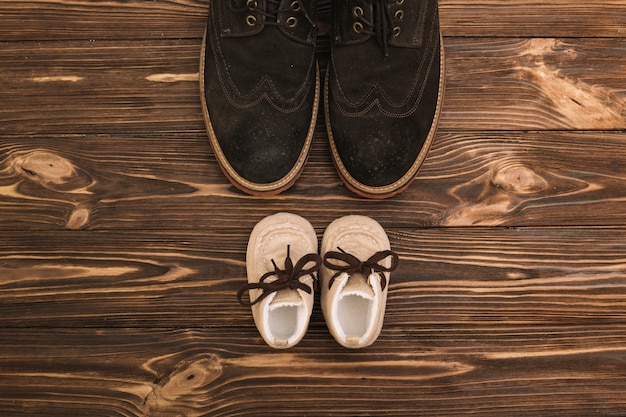 Männliche schuhe in der nähe von kinderstiefeln Kostenlose Fotos