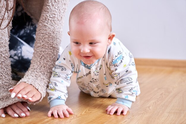 Mama spielt mit ihrem kleinen sohn zu hause auf dem boden