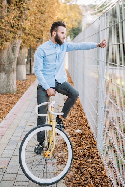 Mann auf fahrrad nahe zaun Kostenlose Foto