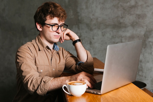 Mann, der an dem laptop im büro arbeitet Kostenlose Fotos