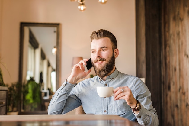 Mann Der Im Handy Beim Trinken Des Kaffees Spricht Kostenlose Foto