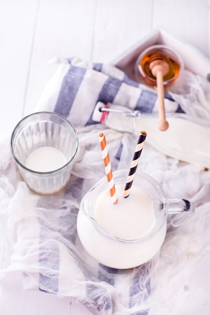 Milch im glas mit strohhalmen und honig PremiumFoto