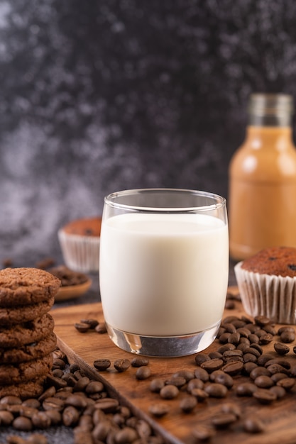 Milch in einem glas mit kaffeebohnen, cupcakes, bananen