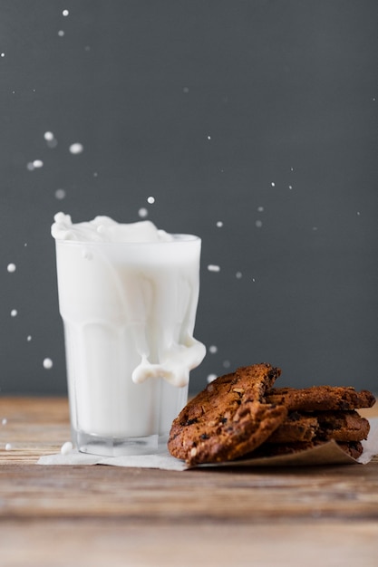  Milch  in glas mit keksen  bespritzt Kostenlose Foto