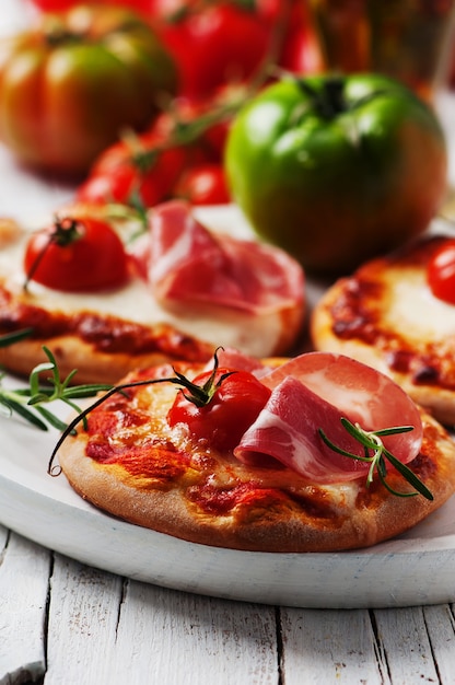Mini-pizza mit mozzarella, schinken und tomate | Premium-Foto