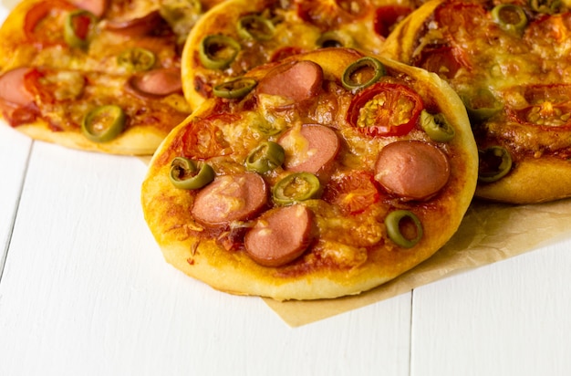 Mini-pizza mit würstchen und tomaten auf hellem hintergrund | Premium-Foto