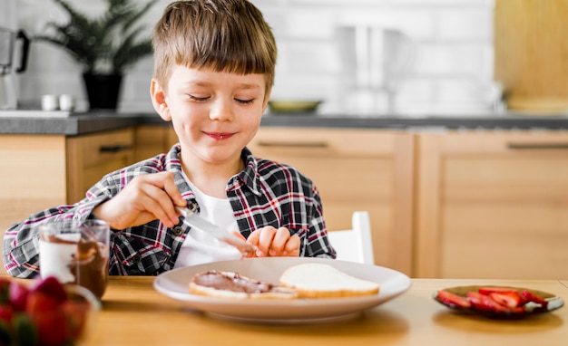 Mittlerer Schuss Smiley Kind Mit Essen Kostenlose Foto