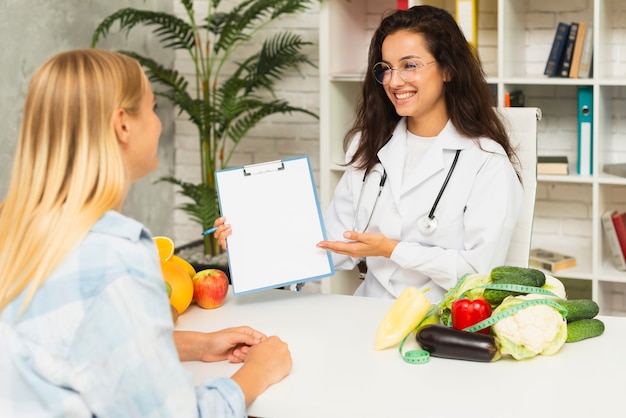 Mittlerer schussdoktor, der dem patienten ergebnisse zeigt Kostenlose Fotos