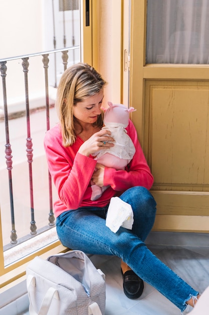 Mutter mit baby vor fenster Kostenlose Foto