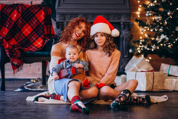 Mutter mit ihrer tochter und ihrem sohn zu weihnachten am weihnachtsbaum Kostenlose Fotos