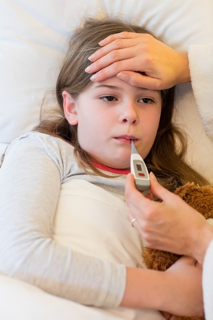 Mutter Überprüfung Fieber ihrer Tochter im Schlafzimmer ...