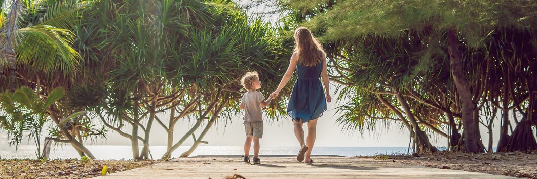 Mutter und sohn gehen zum meeresstrand. resorturlaub am