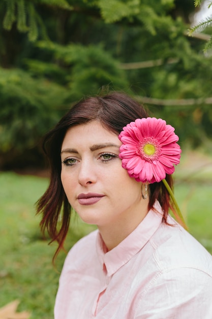 Nachdenkliche frau mit blume im haar | Kostenlose Foto