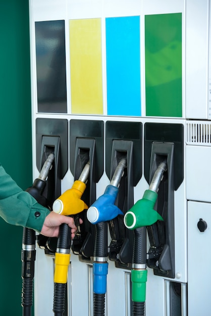 Nahaufnahme der mannhand unter verwendung einer zapfpistole an einer tankstelle. Premium Fotos