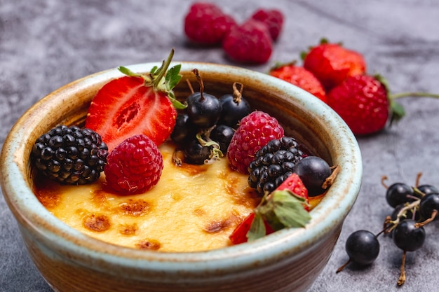 Nahaufnahme der mit beeren garnierten crème brûlée | Kostenlose Foto