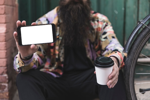 Nahaufnahme des mannes handy und wegwerfkaffeetasse in der hand halten Kostenlose Fotos