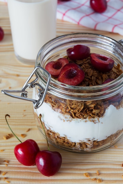 Nahaufnahme von müsli und joghurt mit kirschen und einem