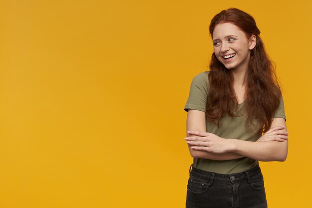 Nette Positive Frau Mit Langen Ingwerhaaren Grunes T Shirt Tragen Menschen Und Emotionskonzept Arme Verschrankt Und Lachelnd Beobachten Sie Links Den Kopierbereich Isoliert Uber Der Orangefarbenen Wand Kostenlose Foto