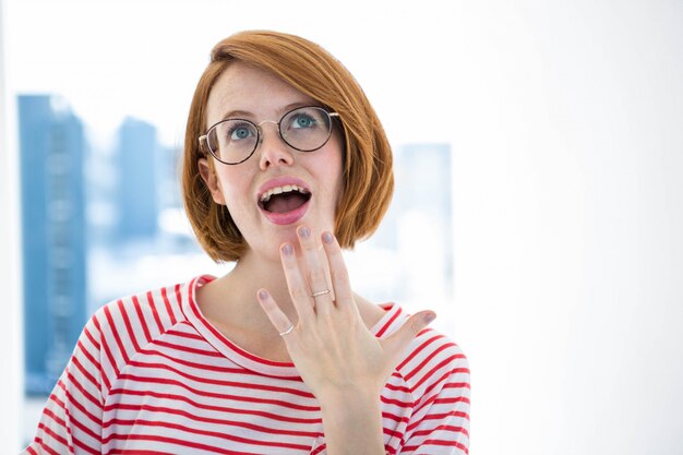 Netter roter behaarter hippie mit gläsern vor einem fenster Premium Fotos