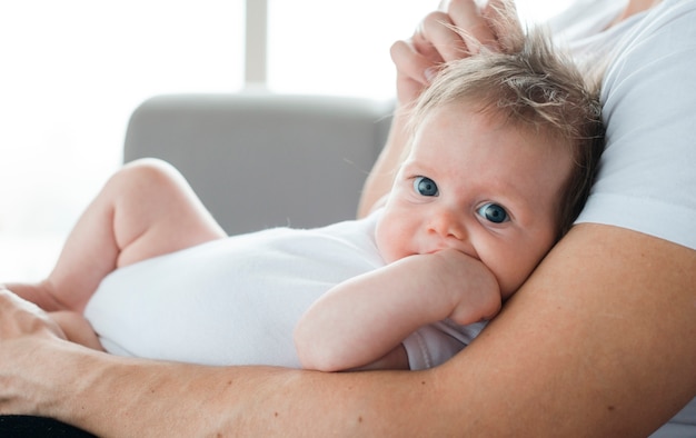 Nettes baby auf vaterarmen zu hause Kostenlose Foto