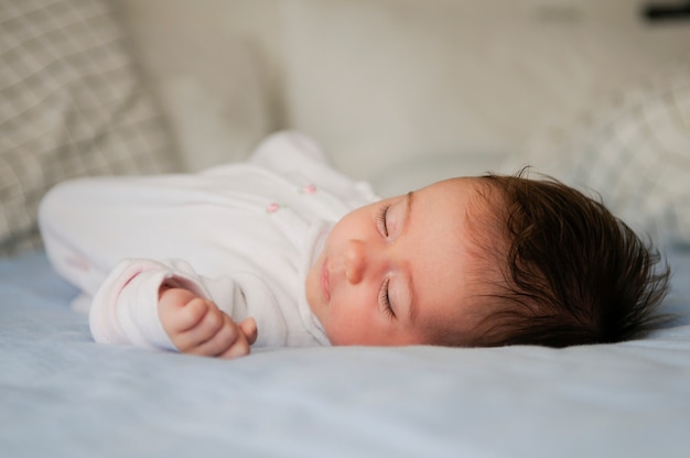 Neugeborenes baby, das zu hause auf blauen blättern