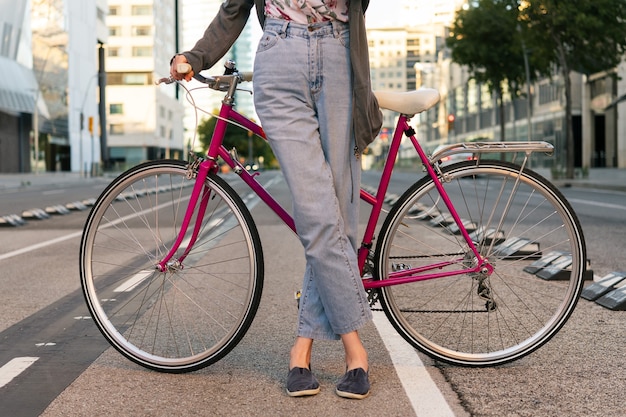 Nicht erkennbare junge frau mit einem rosa retrofahrrad