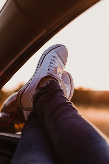 Nicht Erkennbares Modernes Hipster Madchen Das Sich In Einem Auto Entspannt Fusse Vor Dem Fenster Bei Sonnenuntergang Reisekonzept Premium Foto