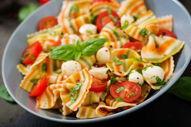 Nudelfarbener farfalle-salat mit tomaten, mozzarella und basilikum ...