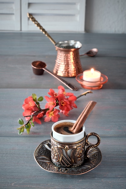 Orientalischer kaffee, der in einer traditionellen türkischen kaffeekanne aus kupfer gekocht und in einer passenden tasse serviert wird Premium Fotos