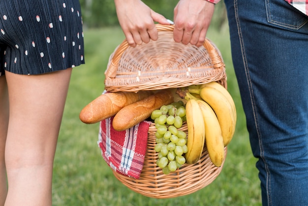 Paare, die einen weg hält einen picknickkorb haben Kostenlose Fotos