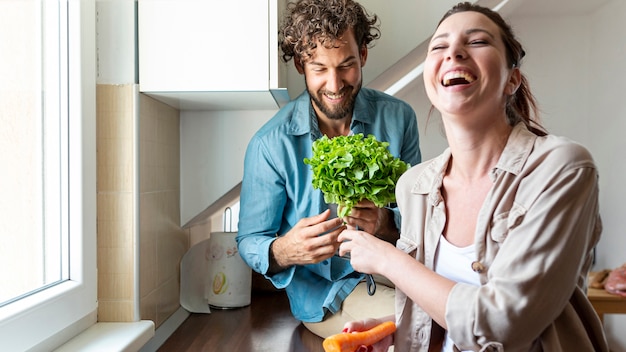 Paare, die spaß beim kochen des abendessens haben Kostenlose Fotos