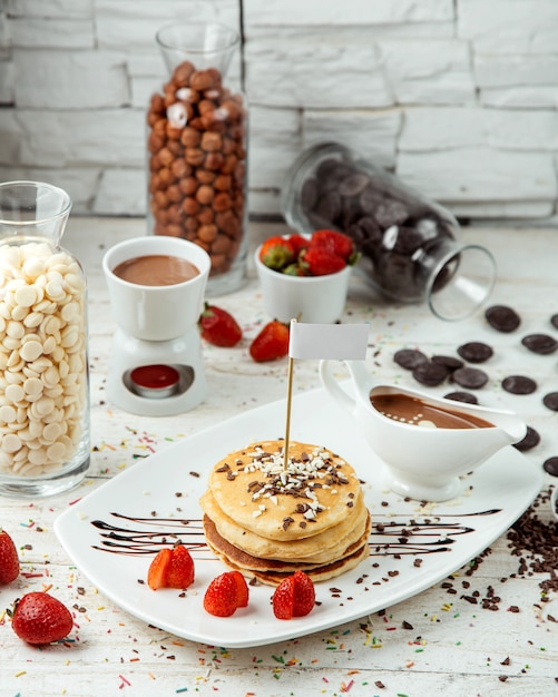Pfannkuchen mit erdbeeren und schokolade auf dem tisch | Kostenlose Foto