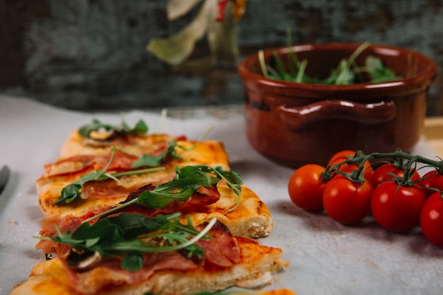 Pizza in der nähe von tomaten Kostenlose Foto